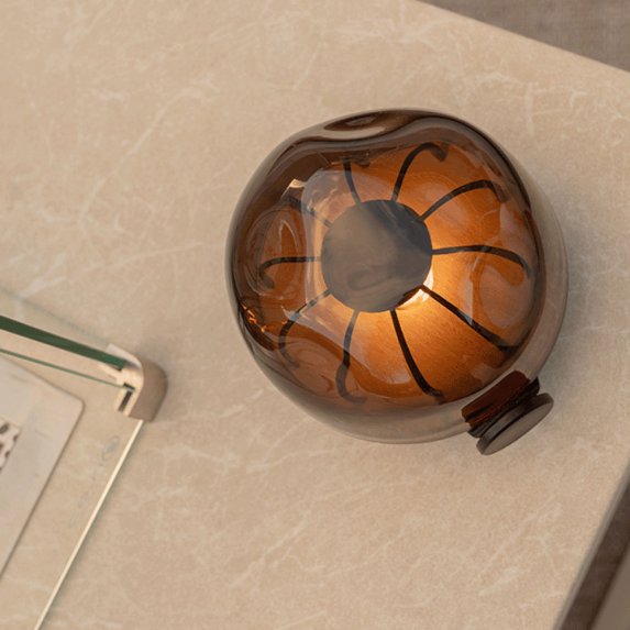 Lhikuva Cosisfera Black LED-tunnelmavalaisimesta vinosti ylhlt katsottuna, miss heijastava savulasi paljastaa pyren, tumman kuvion sisll ja valonlhteen lmpimn hehkun.